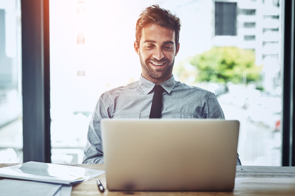 man on laptop smiling